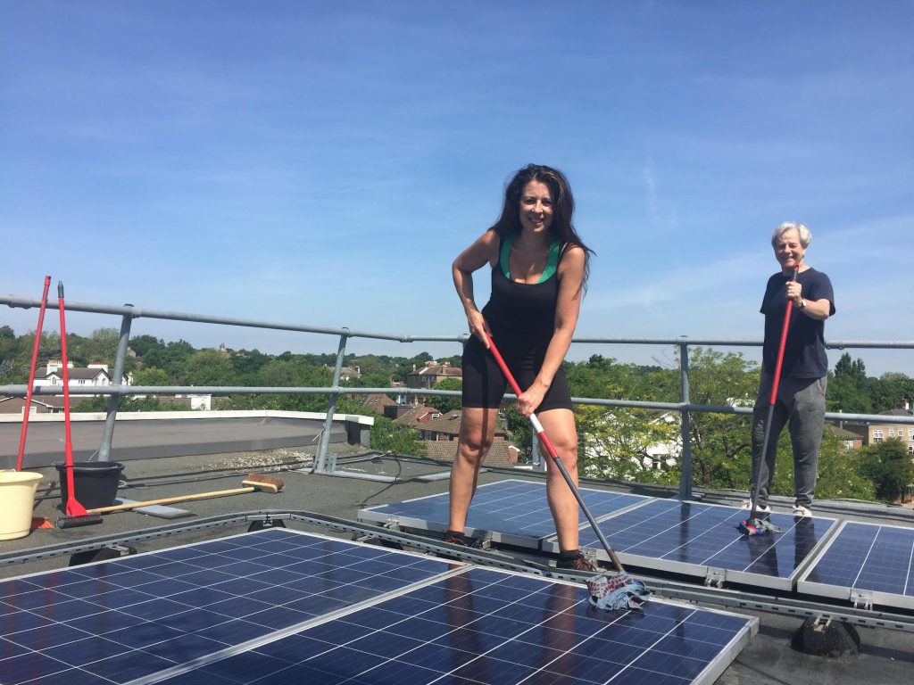 Margy Newens mopping solar panels on the roof of St Christopher's hospice, London. 